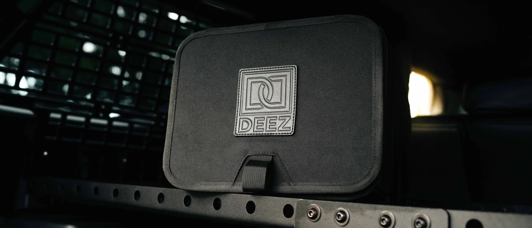 Close-up of the Double Deez Goodz logo on the black fabric lid of the car trash can.